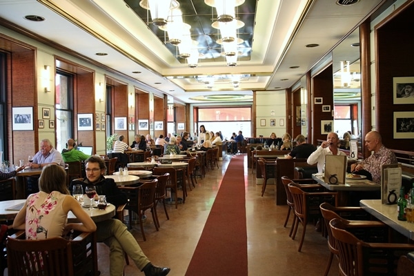 the long dining room of a restaurant with many tables