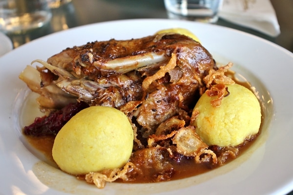 A plate of roasted duck and potato dumplings