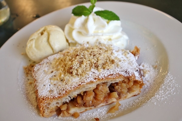 a plate of apple strudel with ice cream and whipped cream