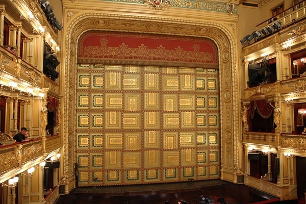 a gold curtain hiding the stage in an opera house