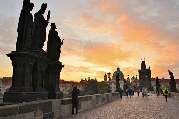 A group of people on the Charles Bridge at dawn