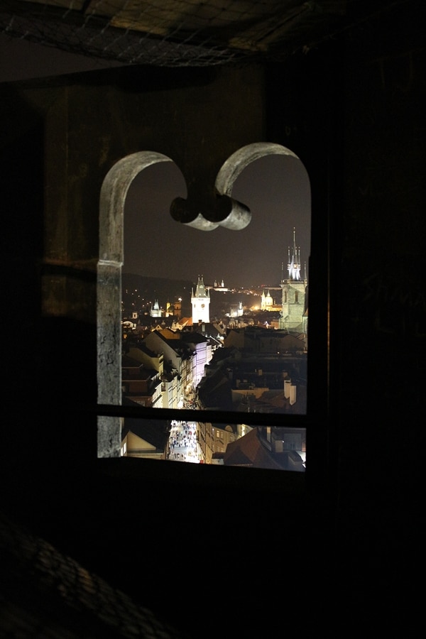 nighttime view of Prague through a window opening