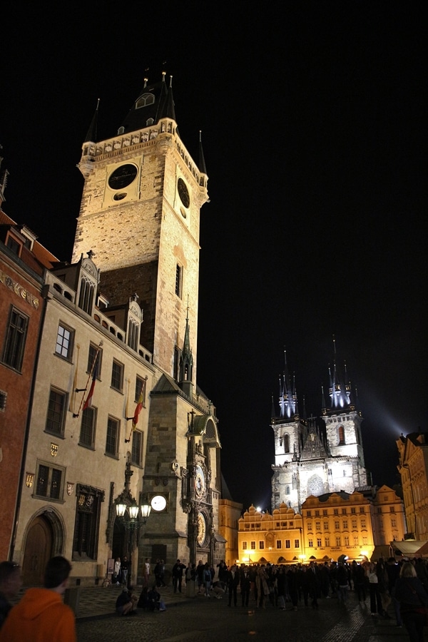 A clock tower and church lit up at night