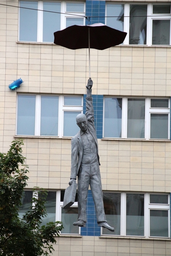 a statue of a man hanging from an umbrella