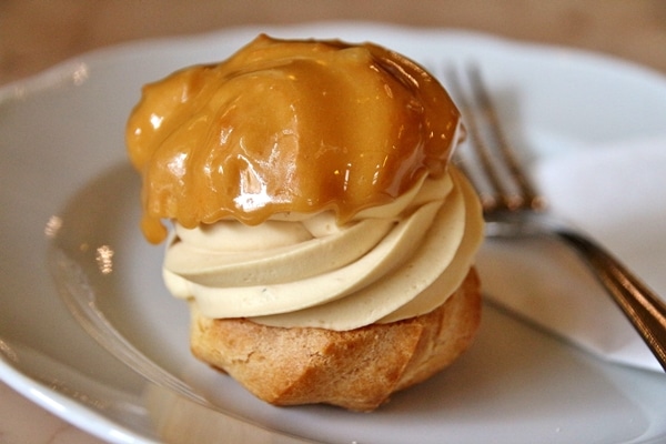 A close up of a small caramel profiterole