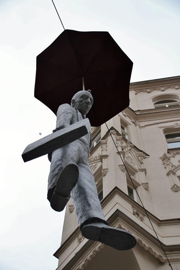 view looking up at a statue of a man hanging from an umbrella