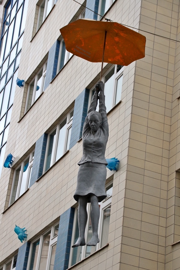 statue of a woman hanging from an umbrella