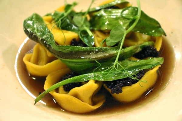 closeup of tortellini pasta with caviar and greens