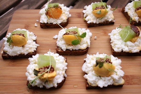 open-faced egg sandwiches on a wooden board