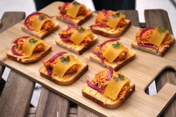 open faced chicken and peach sandwiches on a wooden board