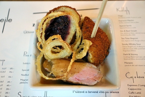 a small plate of duck with fruit-stuffed dumpling