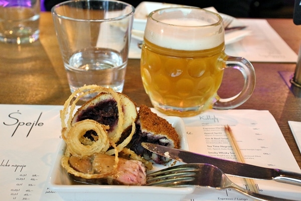 a plate of food and a mug of cold beer