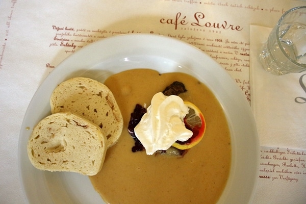 braised beef with creamy sauce, whipped cream, and bread dumplings on a white plate