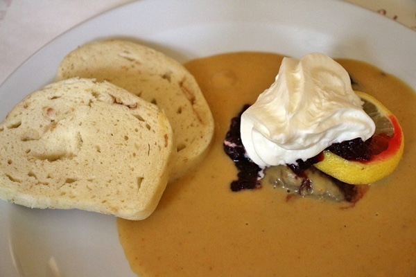 braised beef with creamy sauce and steamed dumplings on a white plate