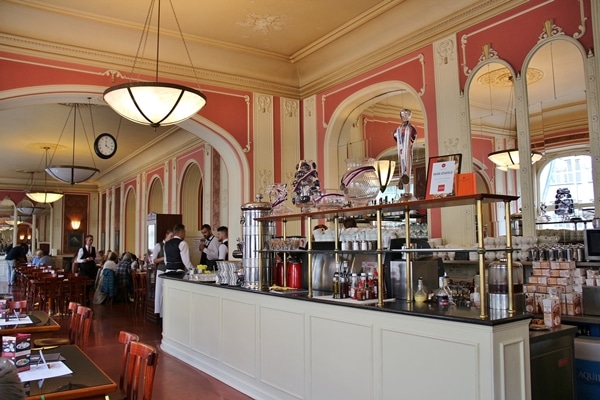 Cafe Louvre interior with pink wallpaper and coffee area