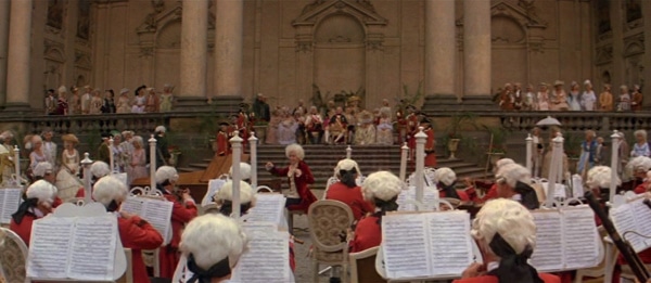 screenshot from the film Amadeus of Mozart conducting an orchestra