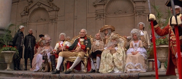 screenshot from the movie Amadeus of the emperor and others watching a concert outdoors