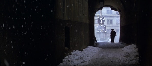 screenshot from the movie Amadeus of a man walking down a snowy tunnel