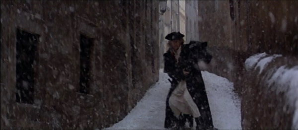 screenshot from the film Amadeus of a man walking down a snowy narrow street