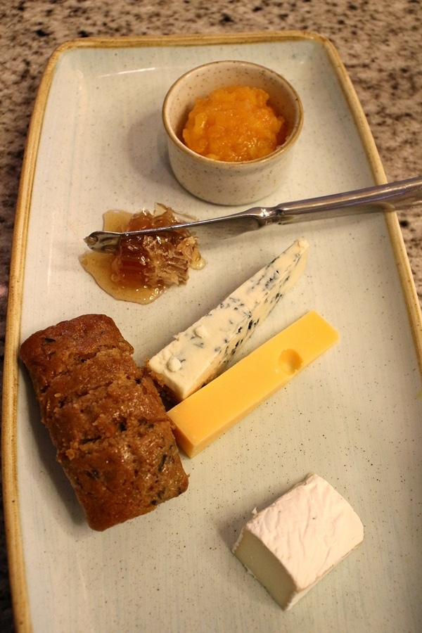 a cheese plate with honeycomb and apricot preserves