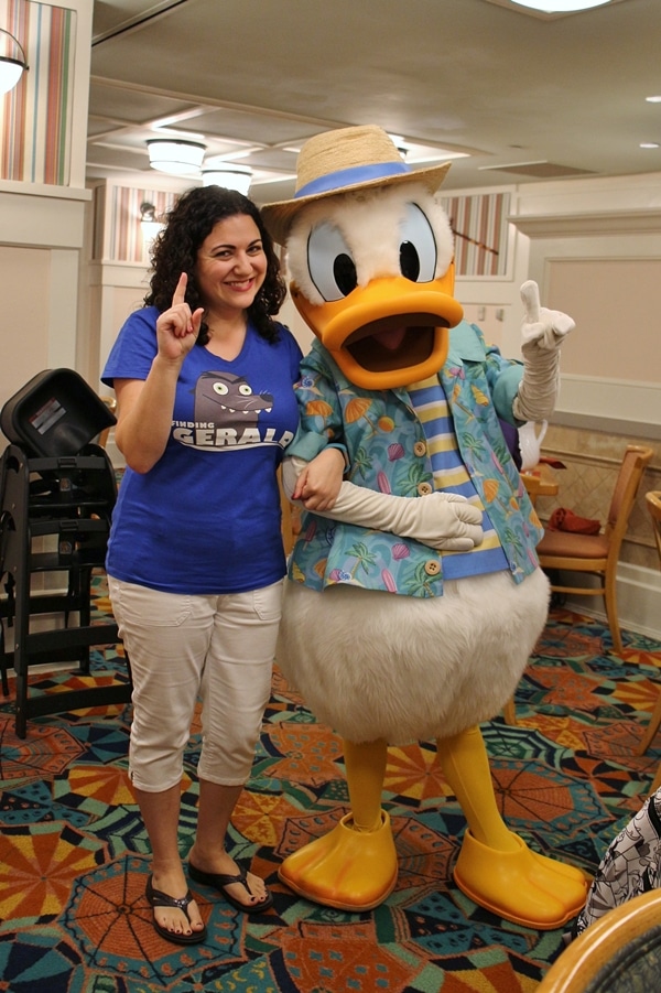 A woman posing with Donald Duck