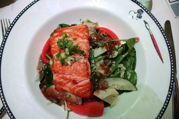 a salad topped with salmon filet