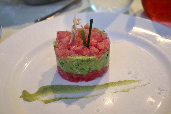 a raw tuna and avocado tower on a white plate