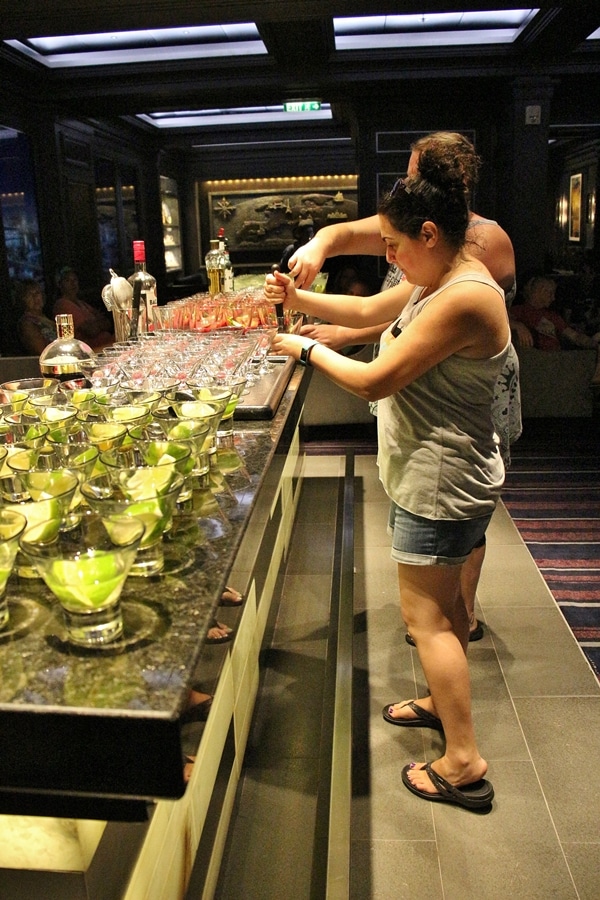 a woman making a cocktail at a bar