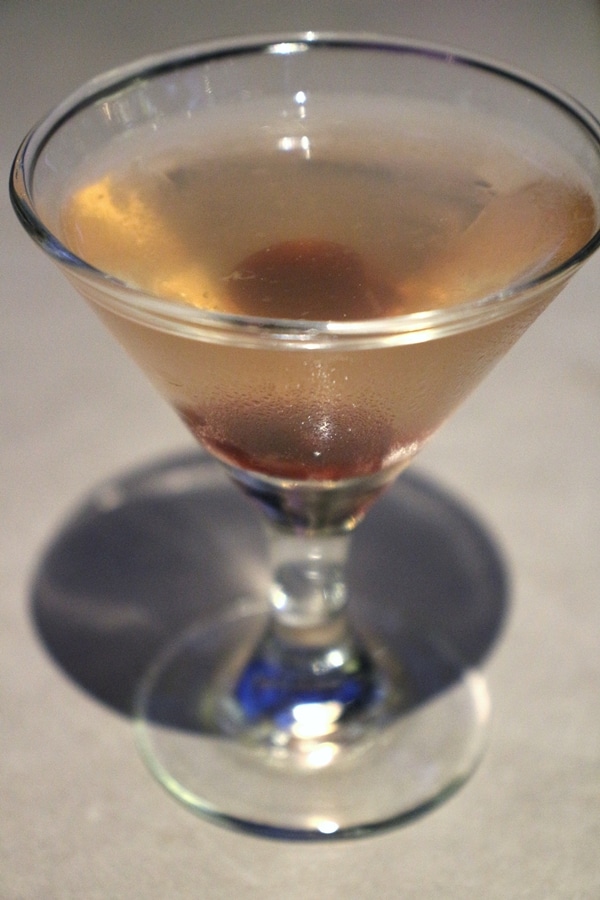 a small cocktail with a cherry garnish