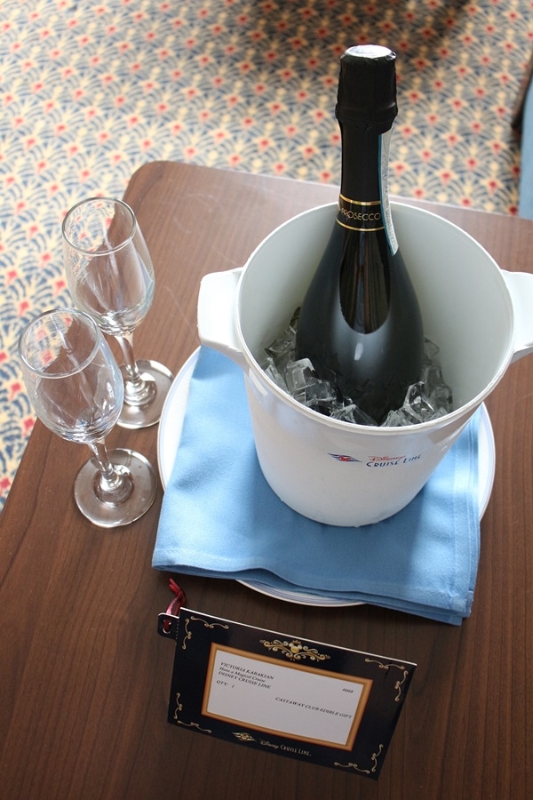 a bottle of Champagne in an ice bucket with glasses on the side