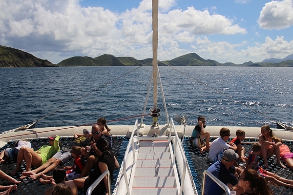 A group of people on a catamaran sailing through the water