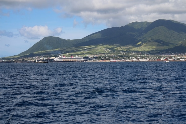 A large body of water with a cruise ship and mountain in the background