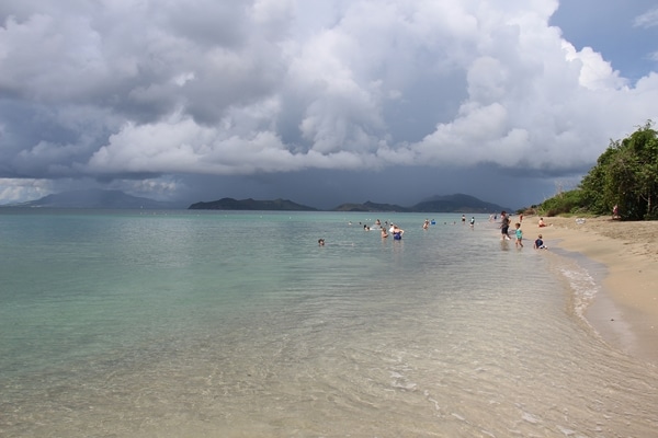 A calm beach with a storm in the distance