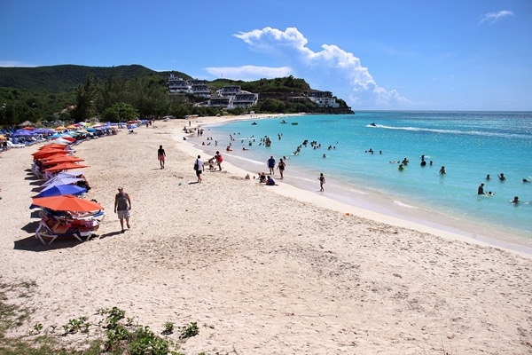 A group of people on a Caribbean beach with turquoise water