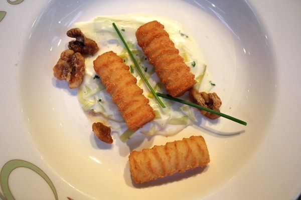 a plate of potato croquettes with creamy leek sauce