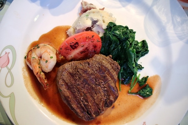 filet mignon with shrimp, mashed potatoes, and spinach on a white plate
