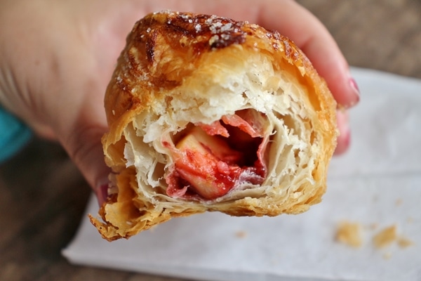 a flaky pastry with a bite taken out showing guava and cheese filling