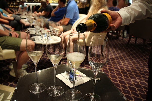 a server pouring Champagne into glasses