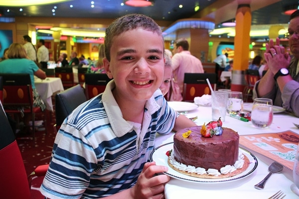 A person sitting at a table with a birthday cake