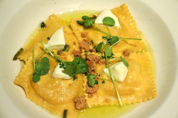 large raviolis in a butter sauce with fresh herbs on top