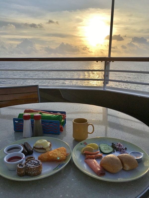 plates of food on a table overlooking the water on a cruise ship