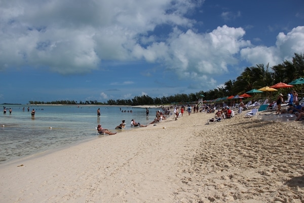 A group of people sitting on a sandy beach