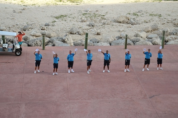 a group of people wearing Mickey Mouse hands, waving goodbye