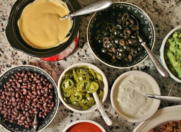 Nacho Bar with Taco Meat, Nacho Cheese Sauce, Guacamole, Salsa, Olives, Beans, Pickled Jalapenos, and Sour Cream