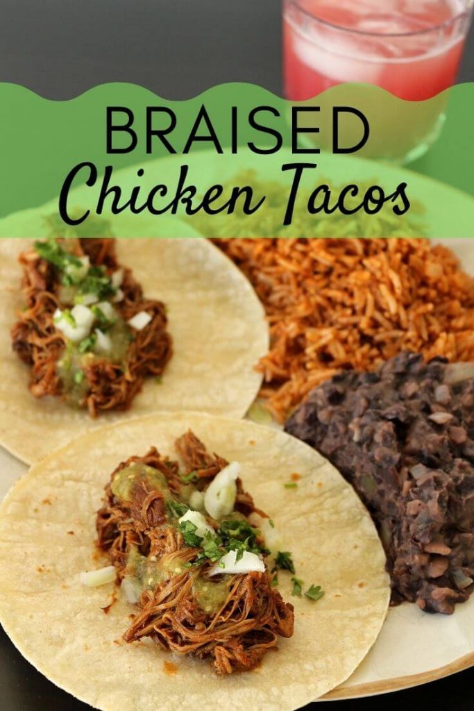 Two braised chicken tacos with salsa verde, cilantro and chopped onion, served with refried black beans and Mexican rice