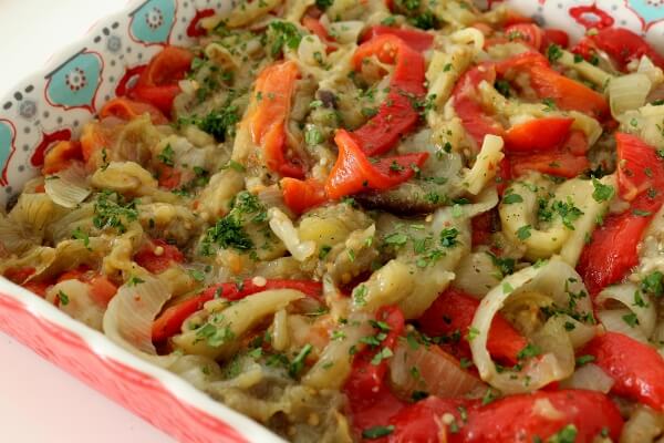 Roasted red peppers, eggplants, and onions with parsley, served in a decorative square dish