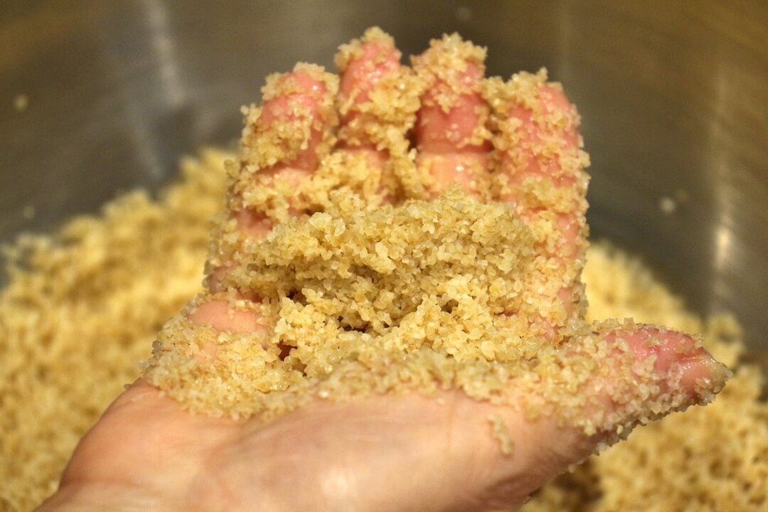 Soaked bulgur clumping up in the palm of a hand