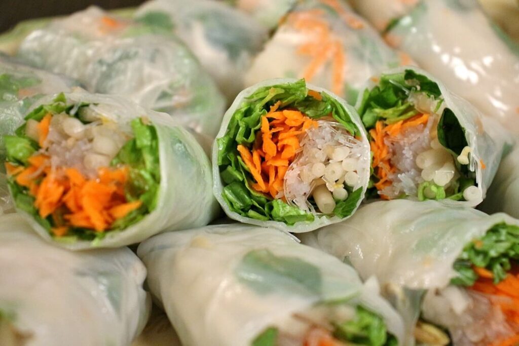 Stacks of nime chow with the cross-sections showing (filled with lettuce, carrots, beansprouts, etc)