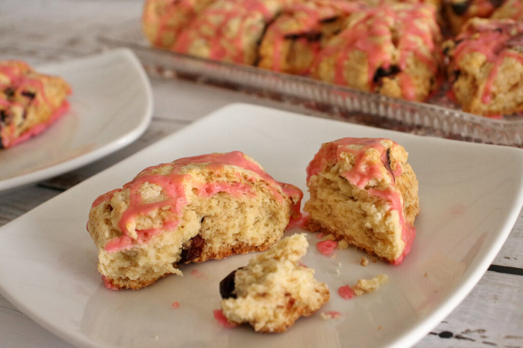 A cherry scone broken into pieces on a plate