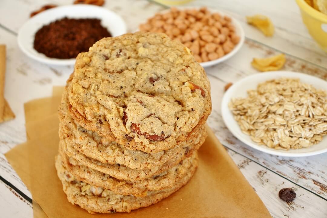 stack of compost cookies surrounded by bowls of ingredients